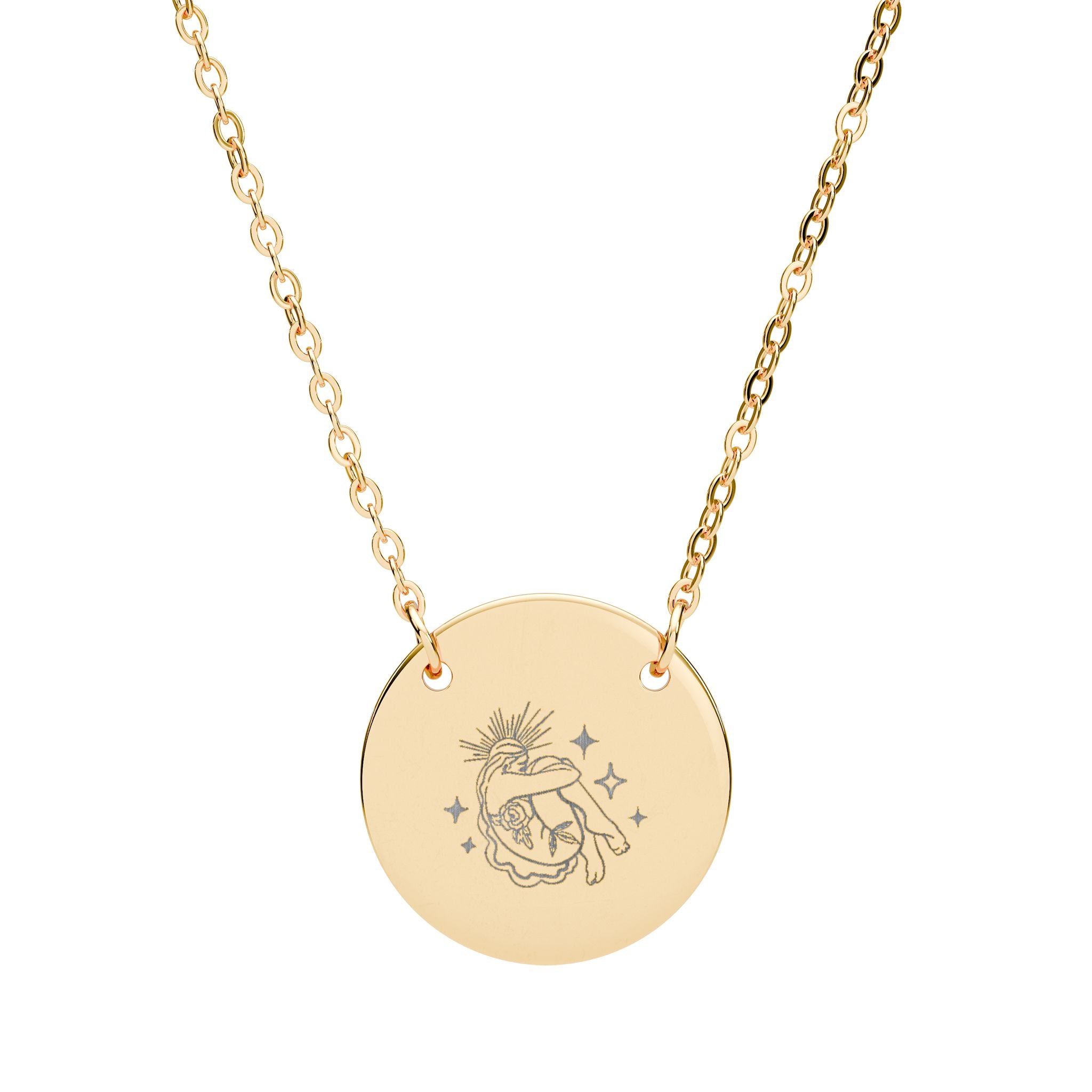 Gold celestial necklace with a round pendant featuring an engraved design on a white background